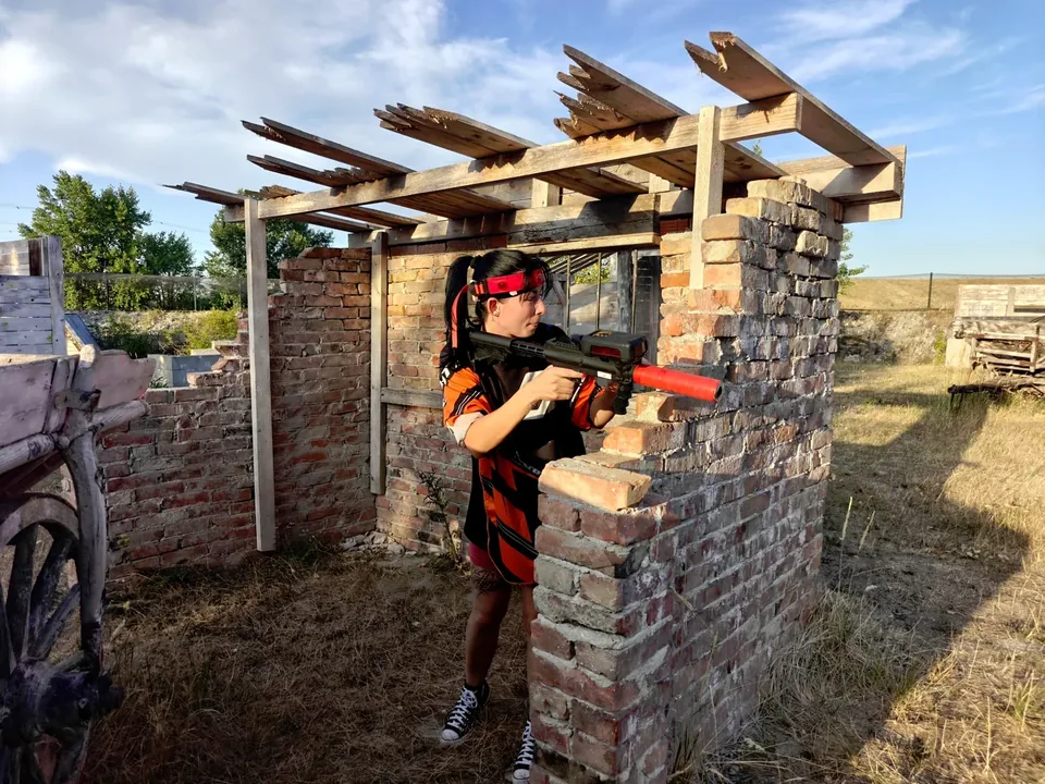 Lasertag in Lassee: Spieler mit Sensor-Stirnband und Lasertagger hinter einer Ziegeldeckung.